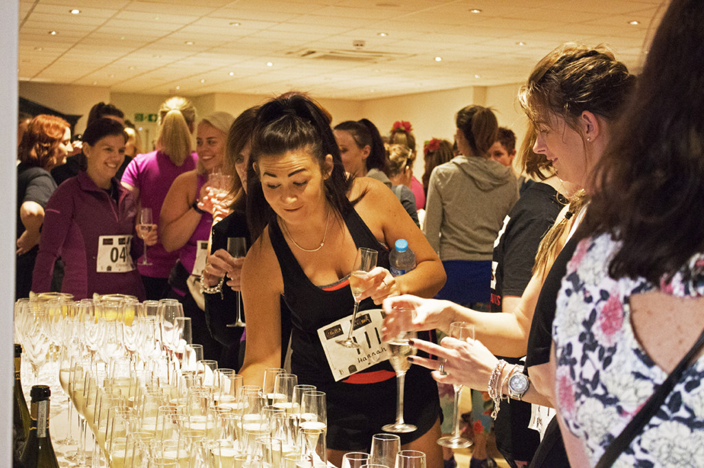 The first lot of women grabbing their drink of prosecco before the start of the run.