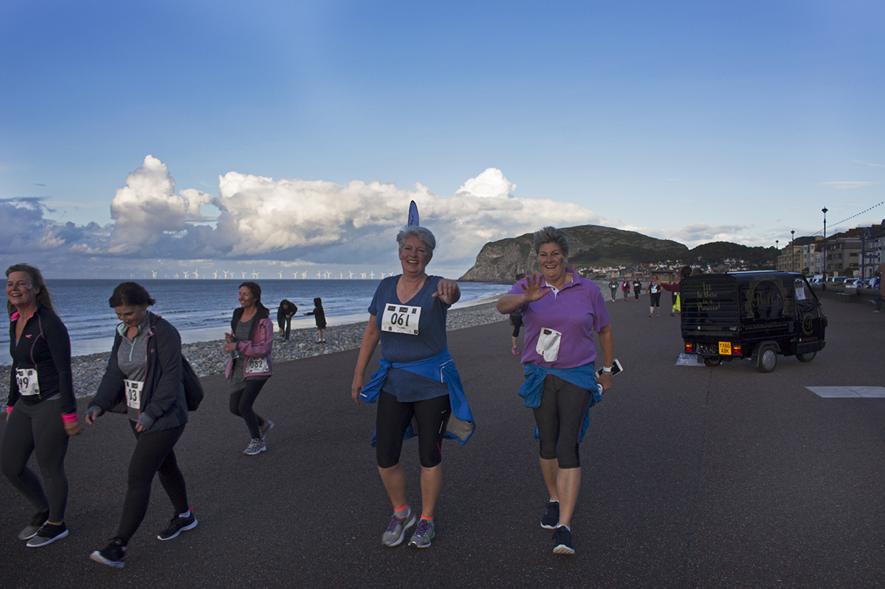 Two of the runners taking time to give the camera a wave as they pass by.