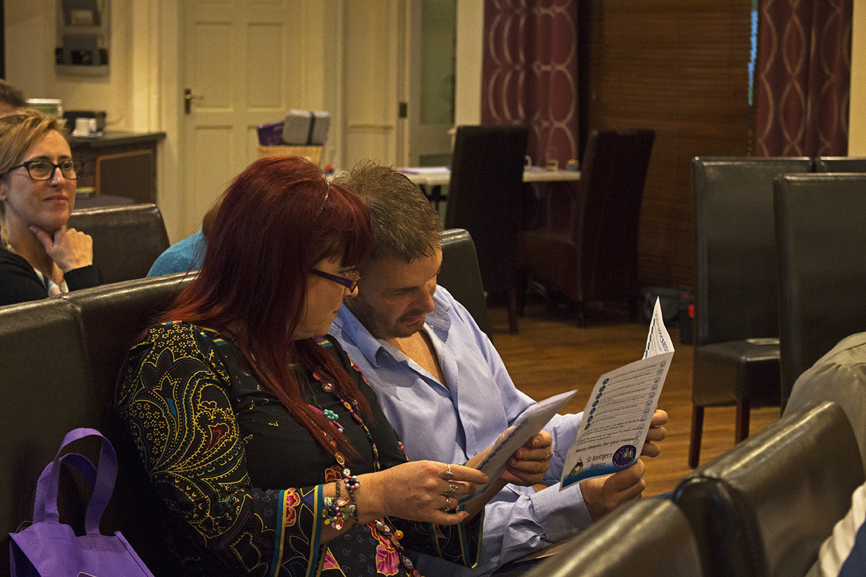Two of the attendees looking through the itinerary so they don't miss the lots they want to bid on.