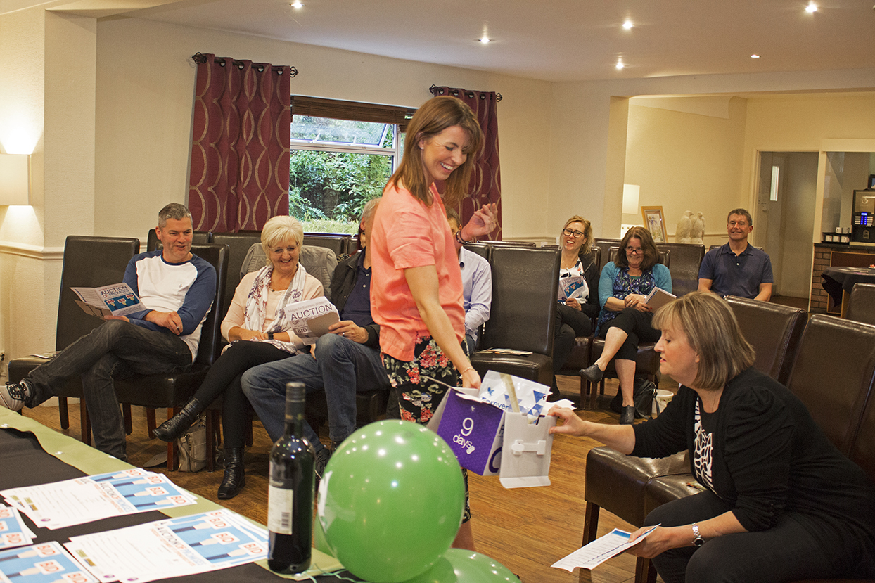 One of the helpers showing one of the lots up for bid.